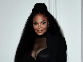 Janet Jackson posando com figurino preto