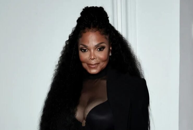 Janet Jackson posando com figurino preto