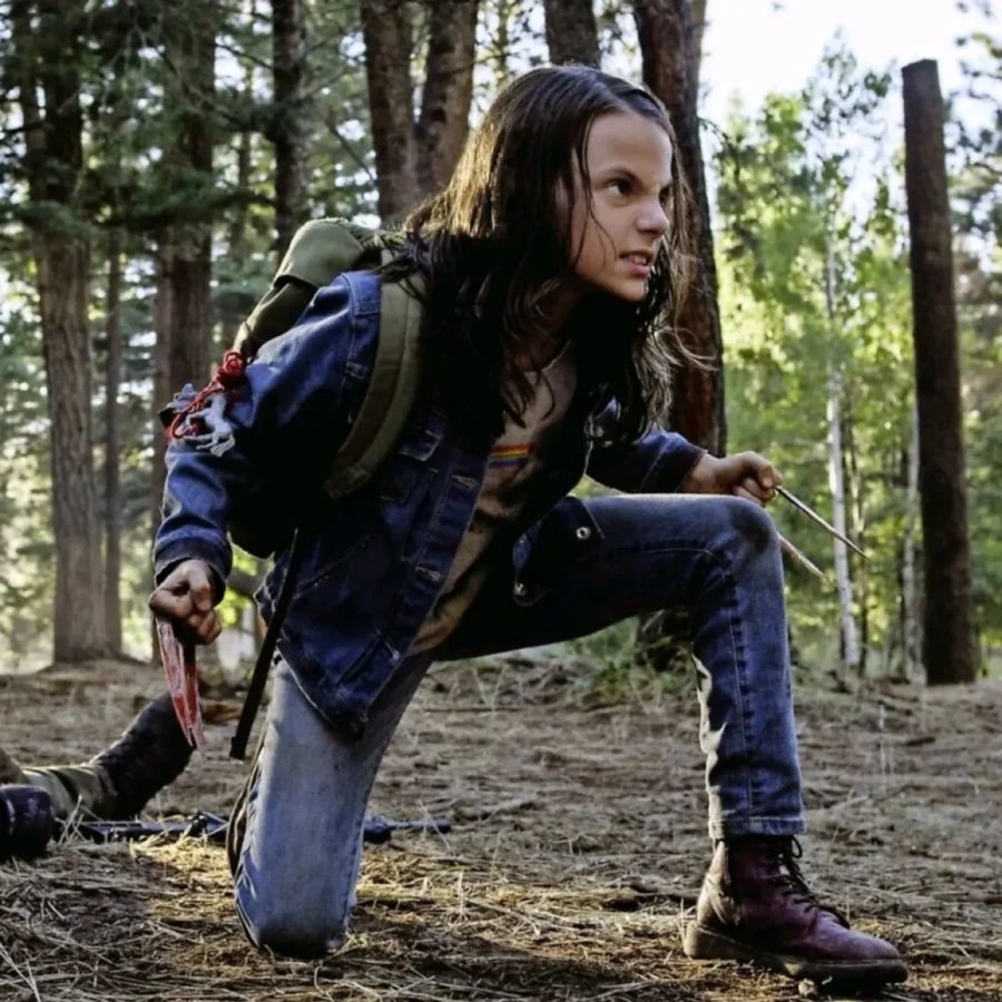 Dafne Keen, atriz mirim, em "Logan", com expressão raivosa e com garras de metal saindo de suas mãos, que estão fechadas. 