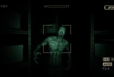 Personagem de Outlast perseguindo outro, em primeira pessoa. Ele pode ser visto apenas por meio da câmera noturna, que traz um aspecto esverdeado para a tela. Crédito: Red Barrels