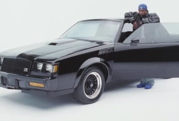 Kendrik Lamar encostado na porta de um GNX, carro que dá título ao álbum.