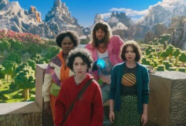 Quatro pessoas aparecem em um local que imita os cenários de um video-game, Na frente, há um garoto pré-aolescente de pele branca, cabelos pretos e cacheados vestindo um moletom vermelho. Ao seu lado, há uma garota da mesma idade, ela tem pele branca e cabelos lisos no tom de loiro escuro. Ela veste um cardigã azul e uma calça verde. Ao fundo existem duas pessoas adultas. A direita, há uma mulher de pele preta e cabelos crespos, ela veste um casaco multicolorido. Ao lado esquerdo há um homem branco, de cabelos compridos e barba no rosto na cor loira.