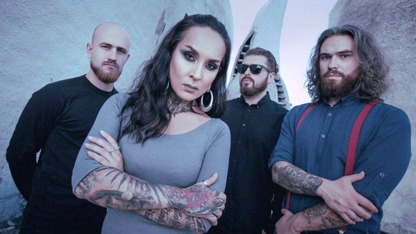 os membros da banda "Jinjer" posam de braços cruzados para a foto. 