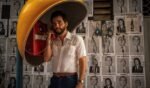 O ator Wagner Moura aparece usando um telefone público em foto de divulgação do filme O Agente Secreto