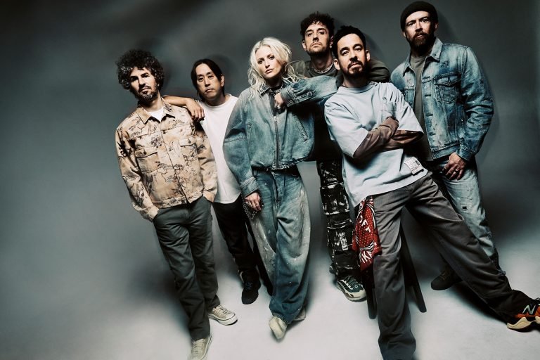 a banda Linkin Park, composta por seis pessoas, sendo cinco homens e uma mulher, posa em uma sessão de fotos para o risco from zero deluxe.